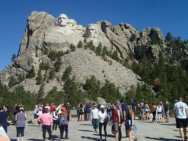 Crowds of visitors on the viewing terrace admiring Mount Rushmore.